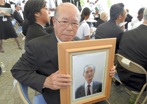 谷口稜曄さんの遺影を手に参列する田中重光さん＝長崎市の平和公園で２０１８年８月９日午前１０時２１分、上入来尚撮影