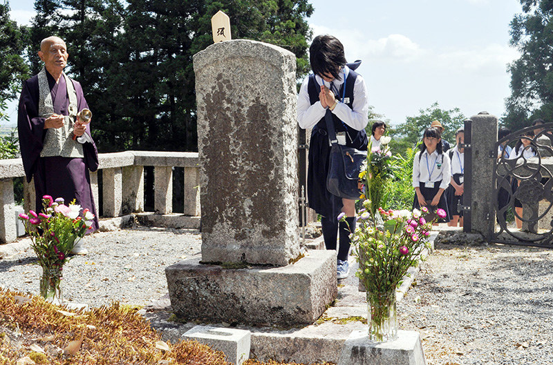 近江で亡くなった近藤重蔵の墓前で手を合わせる根室市の中学生ら=滋賀県高島市勝野の円光寺で、塚原和俊撮影