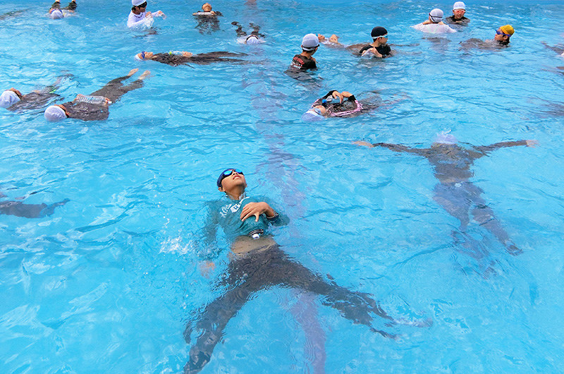 ラッコのように仰向けになって水に浮く児童たち=滋賀県彦根市本町3の市立城西小学校で、同校提供