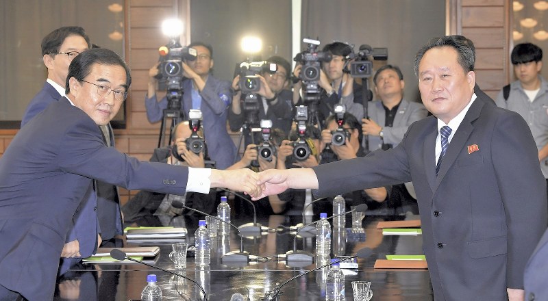 握手する韓国の趙明均統一相(左)と北朝鮮の李善権・祖国平和統一委員会委員長=板門店で2018年8月13日、AP