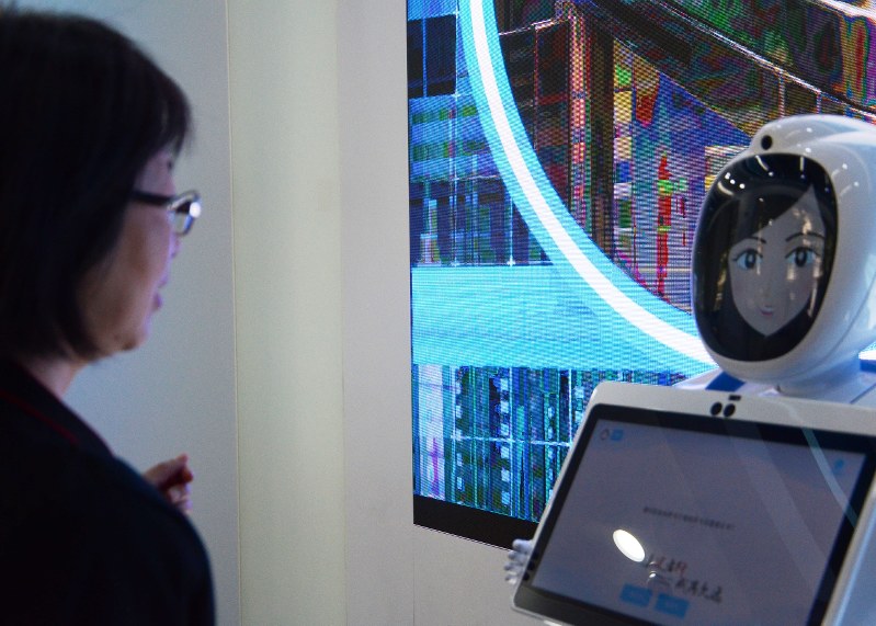 女性客が「どうやって入るの?」と聞くと、ロボットが説明してくれる=上海市の中国建設銀行の無人店舗で、古屋敷尚子撮影