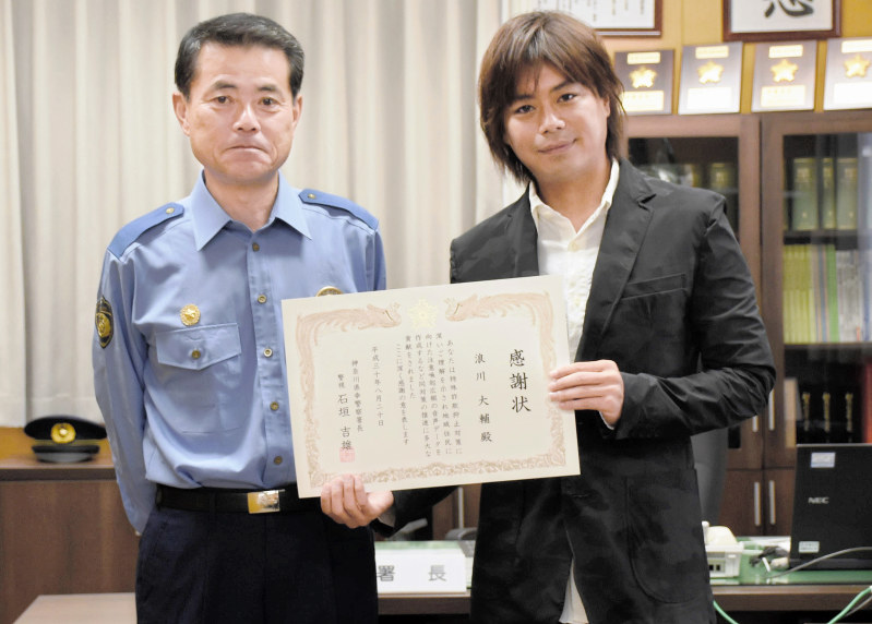 感謝状を受け取った浪川さん(右)と幸署の石垣吉雄署長=川崎市幸区で2018年8月20日、中村紬葵撮影