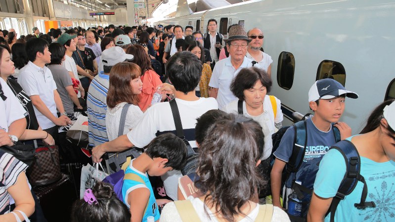 帰省客で混雑する新幹線の下り線ホーム=JR新大阪駅で2018年8月11日