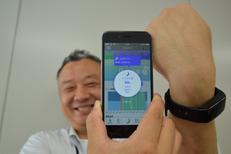 スマートフォンのアプリと活動量計で睡眠不足解消を支援する日立製作所のサービス=東京都港区で、横山三加子撮影