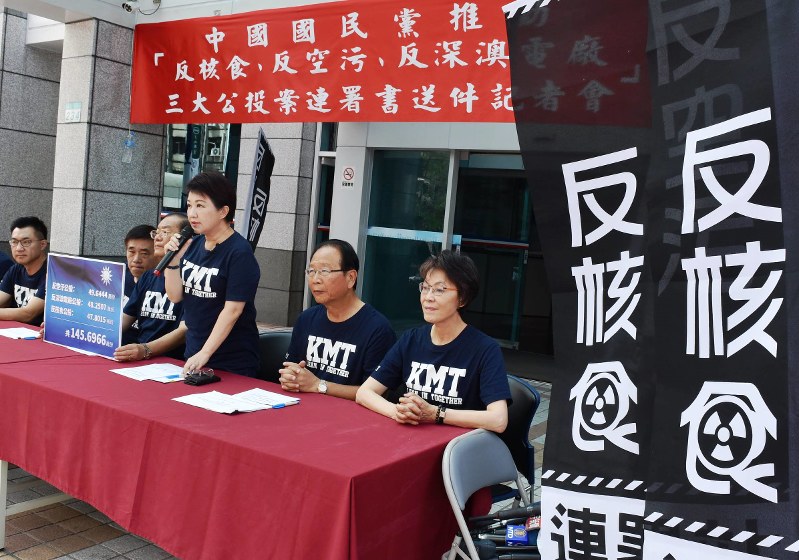 「反核食」(原発事故で汚染された食品に反対する、との意味)と記したのぼりを掲げ、記者会見する国民党の幹部ら=台北市の国民党本部で27日、福岡静哉撮影