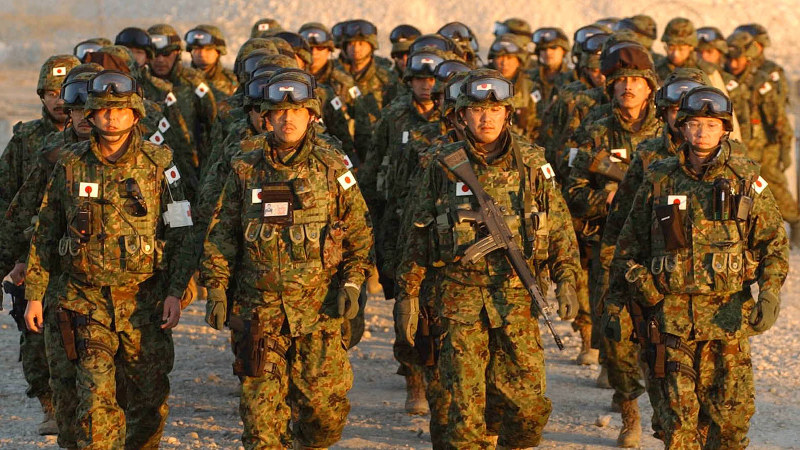 初の「戦地」入りとなるイラクのサマワ到着を報告するため、行進する陸上自衛隊本隊の先発隊員=サマワ駐留オランダ軍宿営地で2004年2月8日、岩下幸一郎撮影