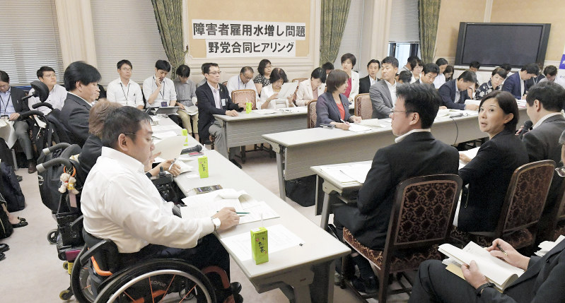 中央省庁が雇用する障害者の数を水増ししていた問題についての野党合同の会合で、厚生労働省などの担当者たち（右手前）の説明を聞く障害者団体の代表者たち（左列）と議員たち（右奥）＝国会内で２０１８年８月２８日午後４時１７分、川田雅浩撮影