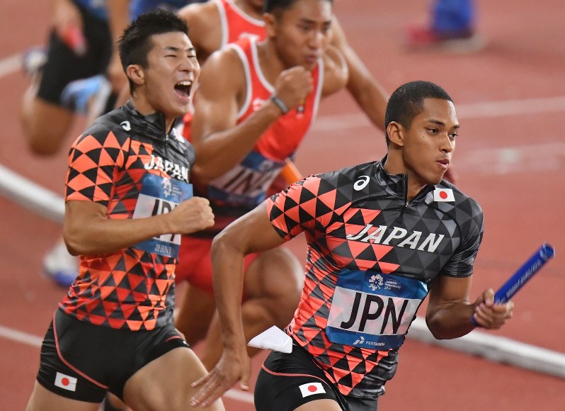 陸上男子400メートルリレー決勝で日本の第3走者の桐生祥秀(左)からバトンを受けるアンカーのケンブリッジ飛鳥=ジャカルタで2018年8月30日、宮間俊樹撮影