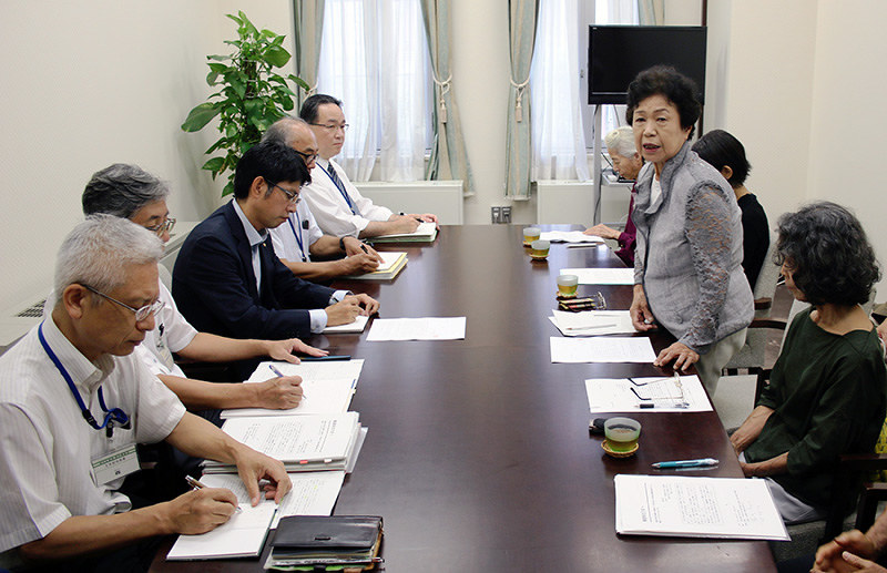 再度の土砂崩れへの不安を京都市都市計画局の鈴木章一郎局長(左側手前から3人目)らに訴える小栗栖自治会の西村嗣子会長(右側手前から2人目)=京都市役所で、飼手勇介撮影