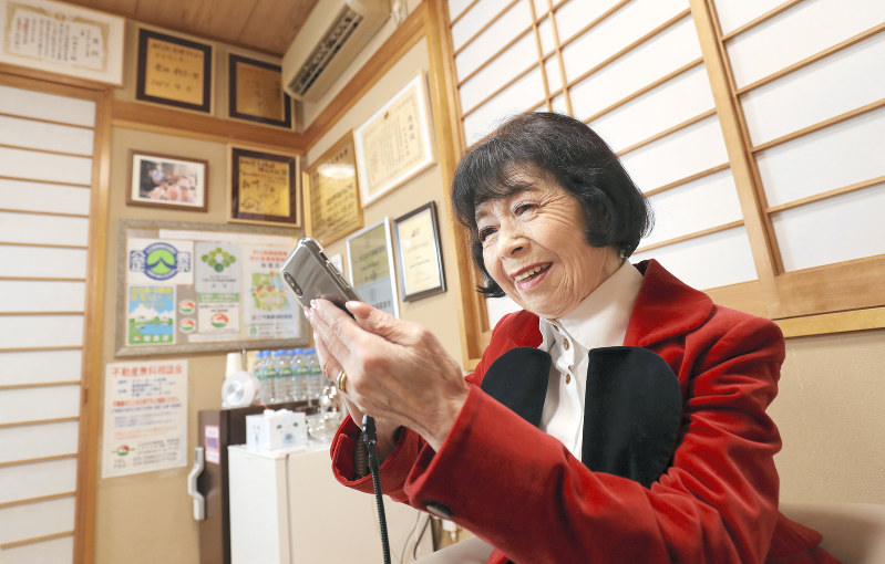 スマートフォンでメールを確認する不動産会社社長の和田京子さん=東京都江戸川区で2018年7月30日、佐々木順一撮影
