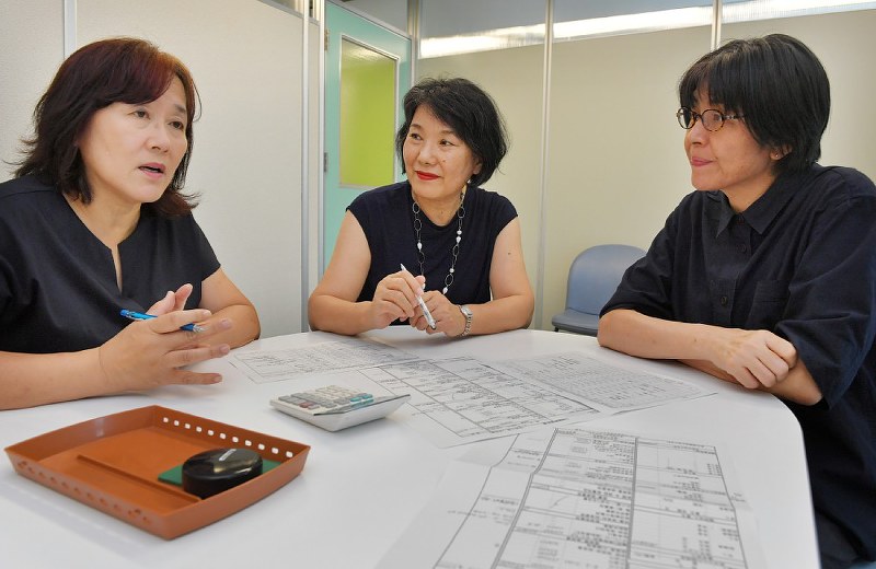 相談者から聞き取った家計収支表を基に話し合うグリーンコープふくおかの行岡みち子室長(中央)ら=森園道子撮影