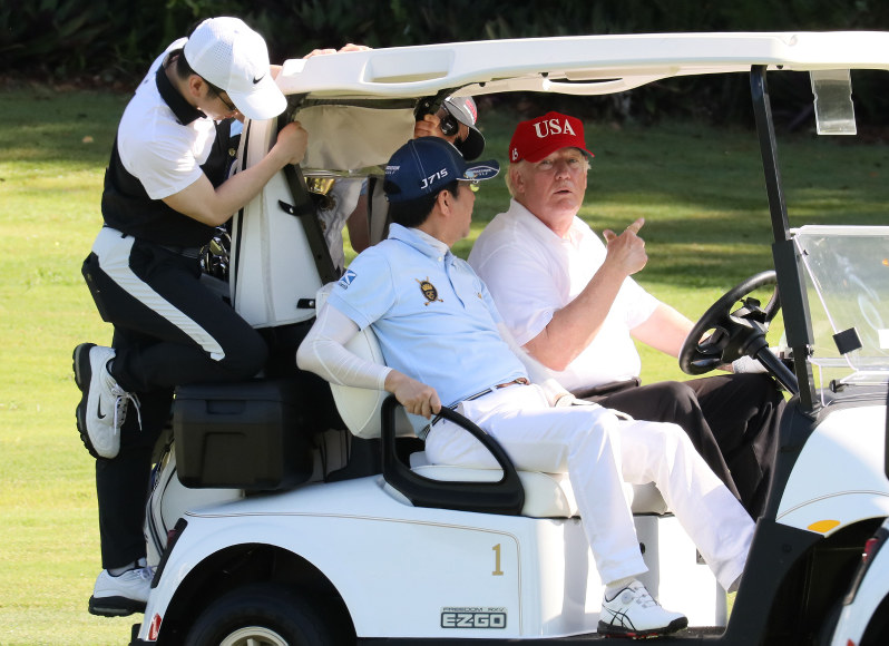 ゴルフ場内をカートで移動しながら会話する安倍晋三首相(中央)とドナルド・トランプ米大統領(右)=米フロリダ州で4月(内閣広報室提供)