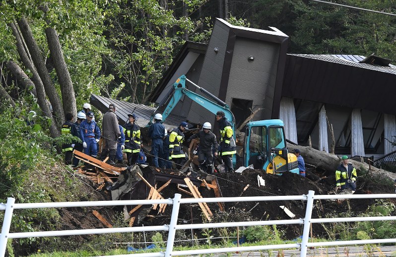 土砂崩れがあった民家の捜索をする消防隊員ら=北海道厚真町で2018年9月6日午前7時29分、竹内幹撮影