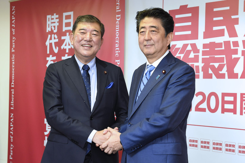 自民党総裁選に向けた共同記者会見の冒頭で握手を交わす石破茂元幹事長(左)と安倍晋三首相=東京都千代田区の同党本部で2018年9月10日午前10時58分、渡部直樹撮影