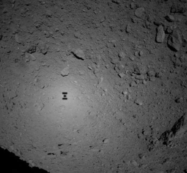 これまでで最も降下した探査機はやぶさ2の影が小惑星リュウグウの表面にくっきりと写った。2018年9月21日午後1時9分に地球へ届いた画像=宇宙航空研究開発機構、東京大など提供
