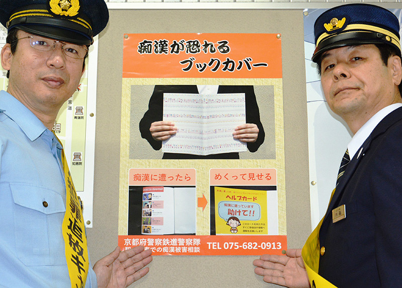 ポスターを張る京都府警鉄道警察隊の足達功隊長(左)と京阪電鉄の内藤賢二・京都エリア統括駅長=京都市東山区の京阪三条駅で、中津川甫撮影