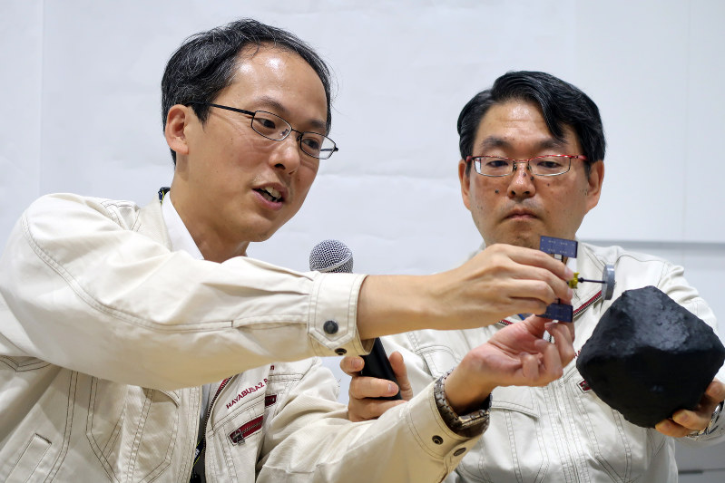 模型を使って、ミネルバ2の分離運用や今後の接近運用について説明する津田雄一・はやぶさ2プロジェクトマネジャー(左)と久保田孝・宇宙航空研究開発機構宇宙科学研究所研究総主幹=相模原市の宇宙航空研究開発機構で2018年9月21日、永山悦子撮影