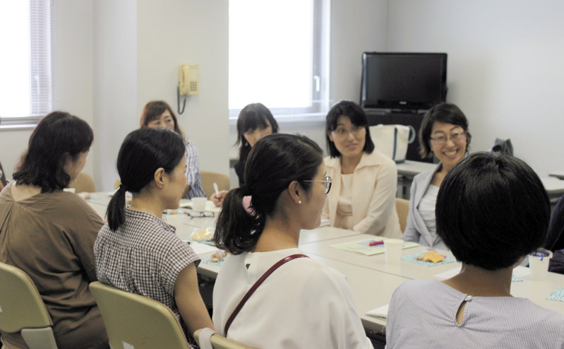 夏休みの過ごし方を話し合う里親ら(後方右端が新井淳子会長、同2人目が福島里美さん)=横浜市都筑区で