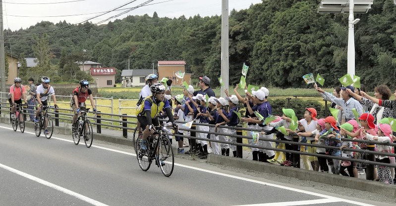 東日本大震災の復興支援イベント「ツール・ド・東北」の出場者に声援を送る沿道の市民ら=宮城県東松島市で2018年9月15日、奥村隆撮影