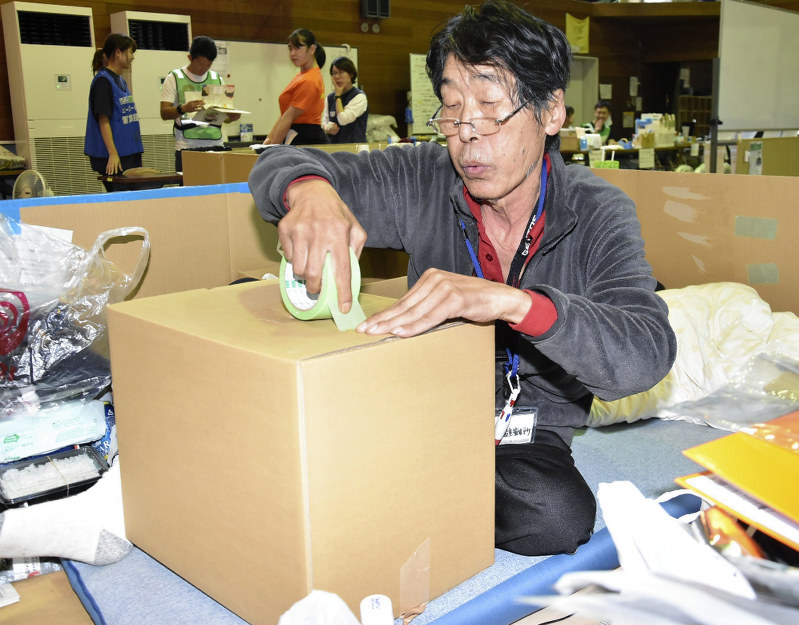 避難所から退所するため荷造りをする男性=岡山県倉敷市真備町上二万で2018年10月6日、益川量平撮影