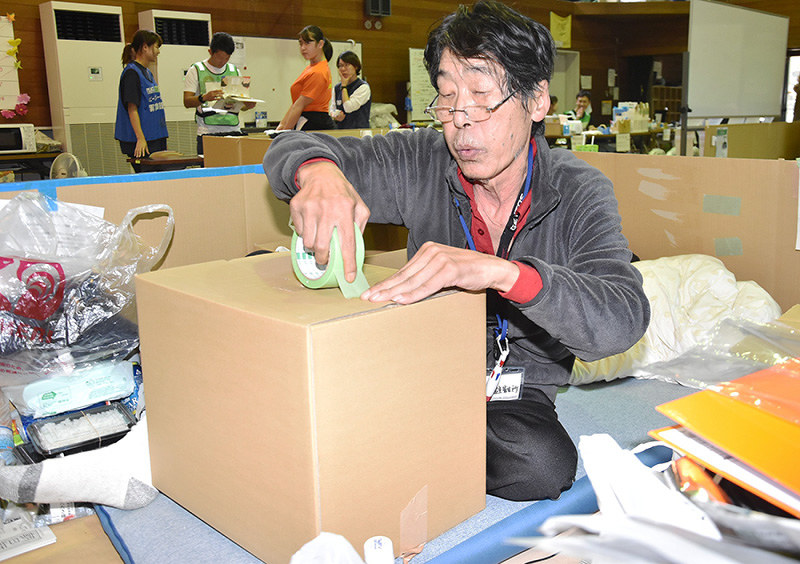 避難所から退所するため荷造りをする男性=岡山県倉敷市真備町上二万で、益川量平撮影