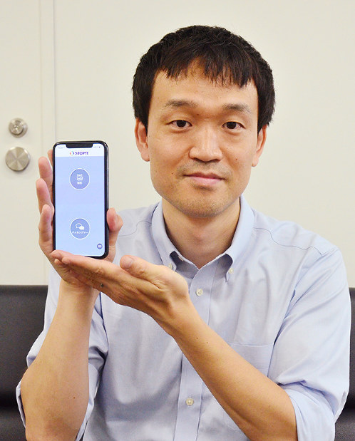 スマホに入ったいじめ相談アプリ「ストップイット」を手にするＩＴ会社社長の谷山大三郎さん＝奈良市で、中津成美撮影