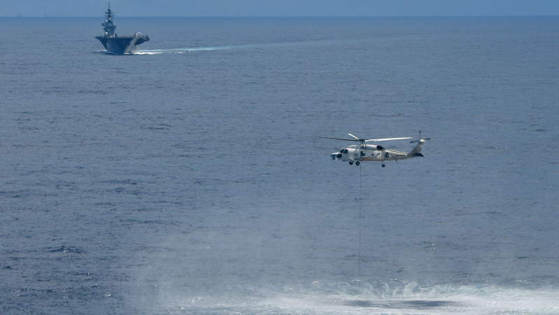 南シナ海で潜水艦の探知訓練をする海上自衛隊の護衛艦「かが」(奥)と搭載ヘリコプター=2018年9月13日(海自提供)