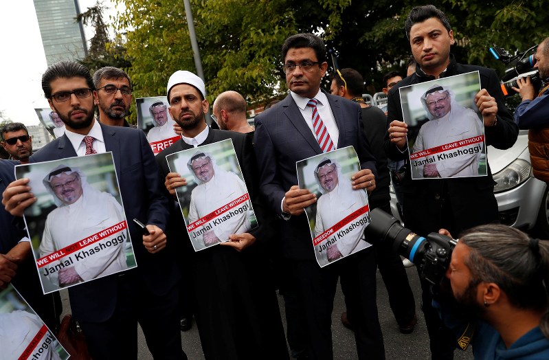 サウジアラビア総領事館の外でカショギ氏の写真を掲げて抗議する人権活動家ら。事件を巡っては発生直後から連日、国内外で報道され関心が高まった=トルコ・イスタンブールで8日、ロイター