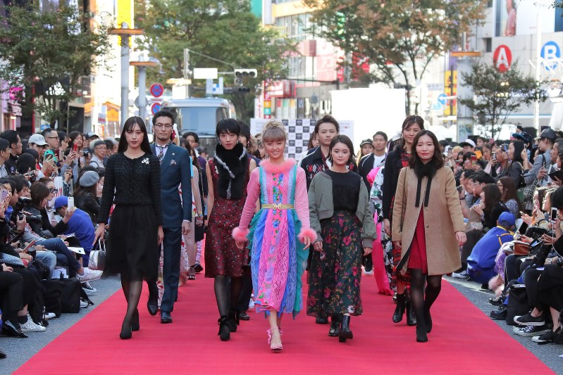 道路に特設されたランウエーを歩くドリームアミさん(中央)らモデルたち=東京都渋谷区で2018年10月21日、和田大典撮影