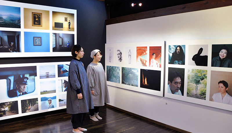 著名人をモデルにした写真が多く並ぶ会場=島根県大田市大森町の群言堂石見銀山本店で、柴崎達矢撮影
