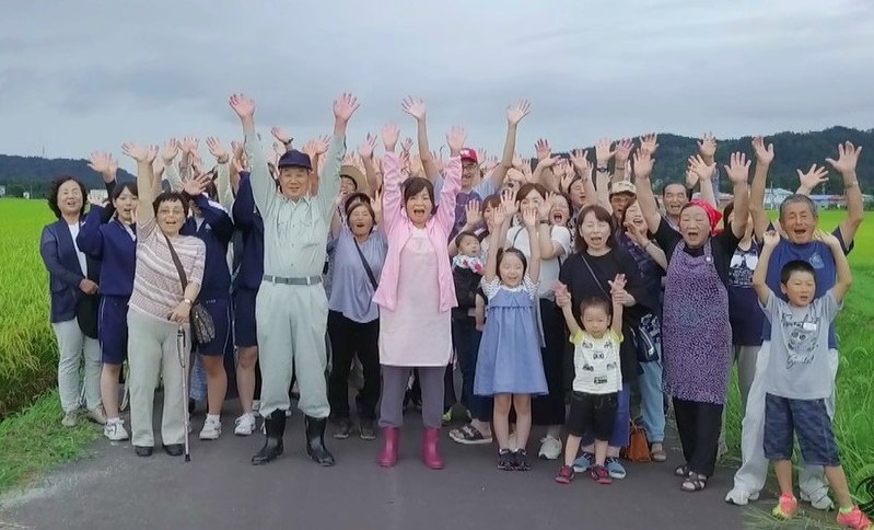 鮭川村PR動画のラストシーンで、大久保佳代子さん(中央)と一緒に村への来訪を呼び掛ける村民たち=鮭川村役場提供