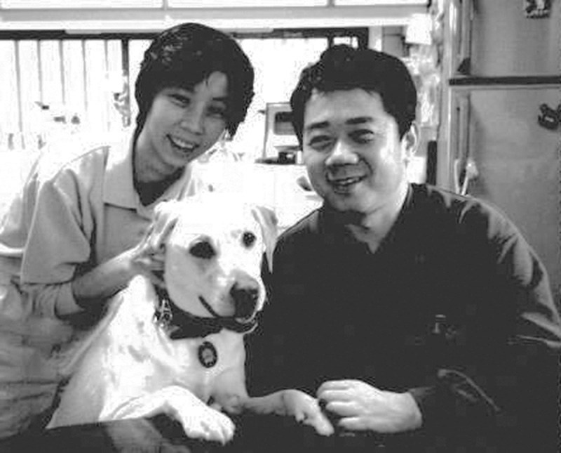 自宅で過ごす1997年6月ごろの木村佳友さん、美智子さん夫妻と介助犬シンシア=写真家の小田哲明さん撮影