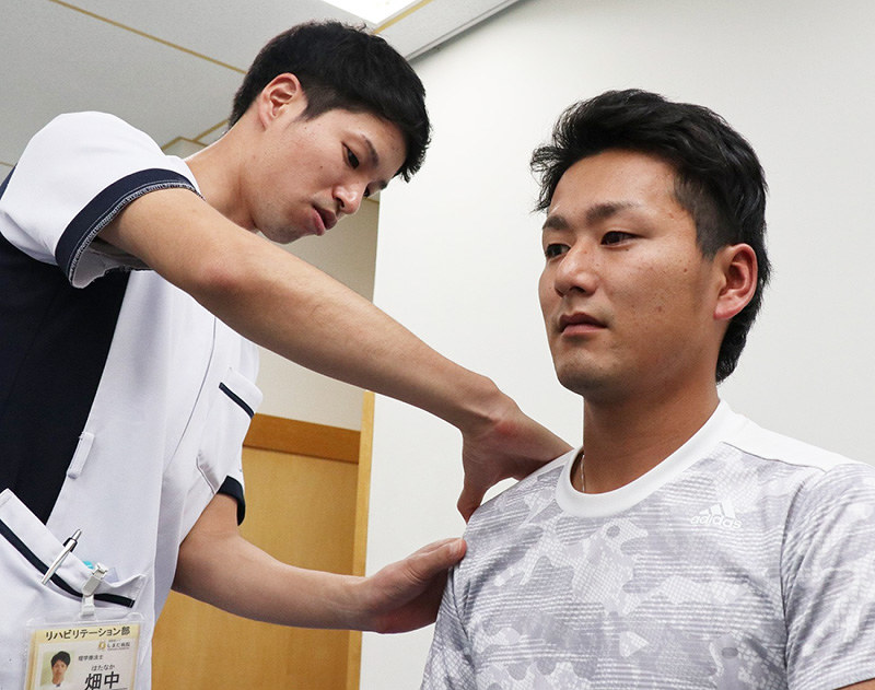 2017年末に痛めた右肩のリハビリを続ける大和高田クラブの安部健太投手(右)=大阪府羽曳野市内の病院で、稲生陽撮影