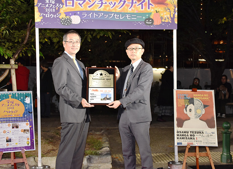 「訪れてみたい日本のアニメ聖地」の認定プレートを披露する兵庫県宝塚市立手塚治虫記念館の河合晋一館長(右)ら=同市栄町で、土居和弘撮影