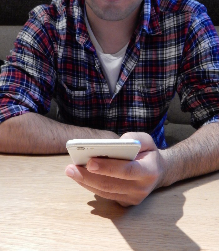 スマートフォンで新疆ウイグル自治区関連のニュースをチェックする在日ウイグル人男性=首都圏で10月、福永方人撮影
