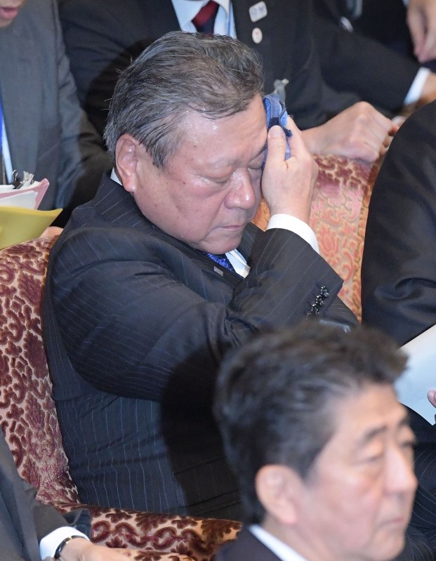 参院予算委員会で汗を拭く桜田義孝五輪担当相。手前は安倍晋三首相=国会内で2018年11月5日、川田雅浩撮影