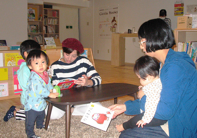 子どもたちに絵本を読み聞かせる母親たち=大阪市東淀川区のちいさな絵本図書館ちっちゃぶっくすで、用貝成子撮影