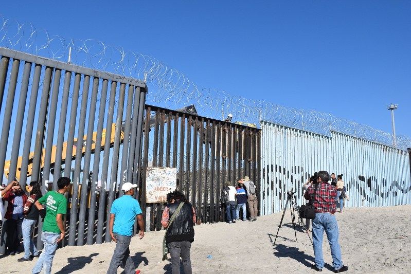 メキシコと米国の国境に立つフェンス。向こうの米国側では、不法入国を阻止するための補強工事が進む=メキシコ北西部ティフアナで11月16日、山本太一撮影