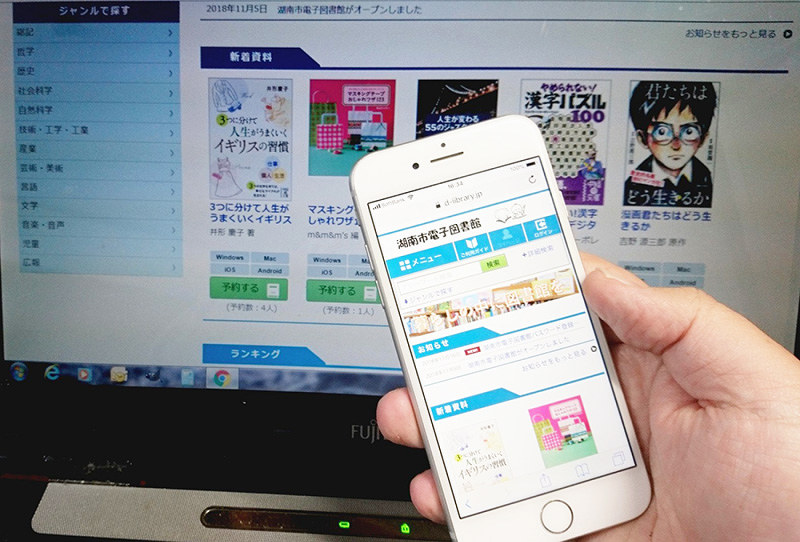 スマートフォンとパソコン上にある「湖南市電子図書館」の画面=礒野健一撮影