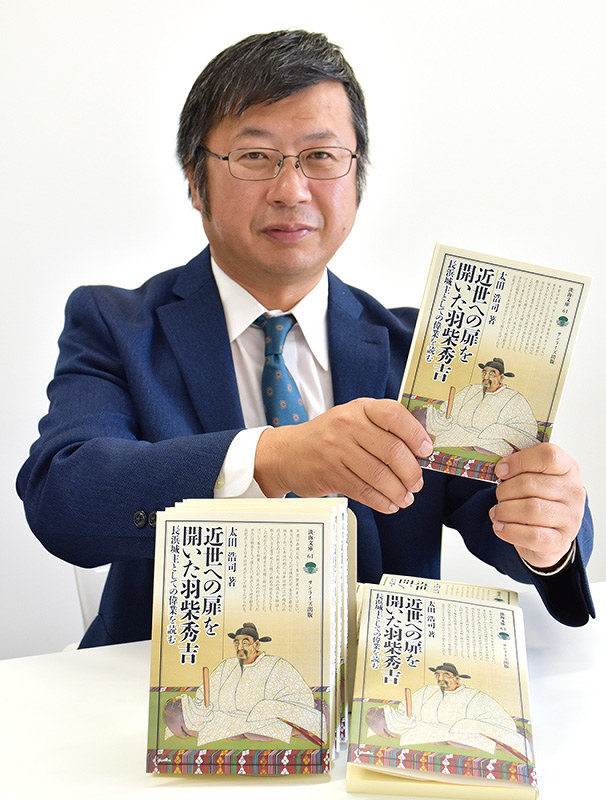 新著「近世への扉を開いた羽柴秀吉」を手にする太田浩司さん=滋賀県長浜市八幡東町で、若本和夫撮影