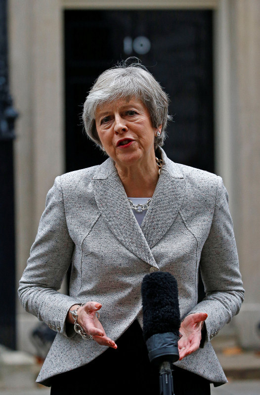 首相官邸前で報道陣に話すメイ首相=ロンドンで22日、ロイター