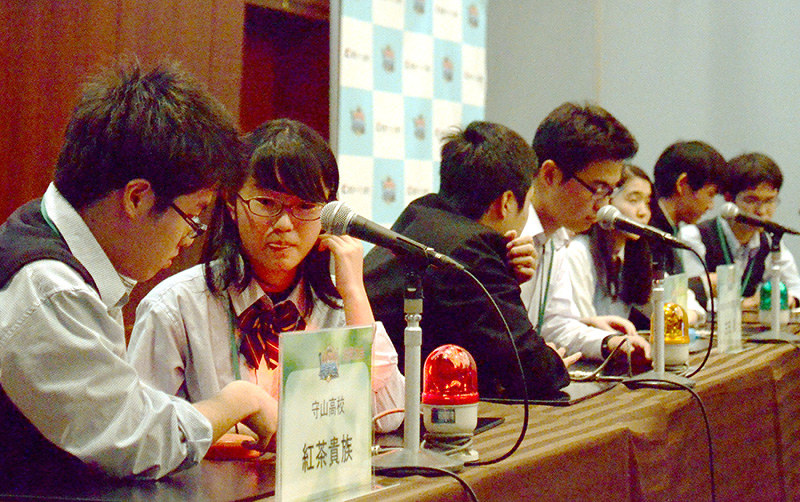 真剣な表情で早押しクイズの問題文に耳を澄ませる高校生=大津市浜町の琵琶湖ホテルで、礒野健一撮影