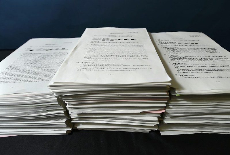 「武器としての情報公開」の著者、日下部聡記者が特定秘密保護法案の取材のために情報公開請求した結果、政府から開示された公文書の一部=2014年8月6日撮影