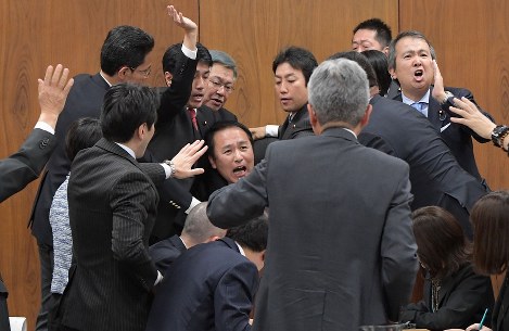 衆院法務委員会での外国人労働者の受け入れを拡大する入国管理法改正案の採決で、葉梨康弘委員長（中央）に詰め寄り阻止しようとする野党議員たち。右端は与党議員たちに賛成起立を促す自民党議員＝国会内で２０１８年１１月２７日午後５時３４分、川田雅浩撮影