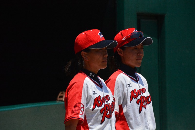 今夏の全国高校女子硬式野球選手権大会で初優勝し、表彰式で選手たちを見つめる京都両洋の上田玲監督(左)=兵庫県丹波市のスポーツピアいちじまで2018年8月3日、石川裕士撮影