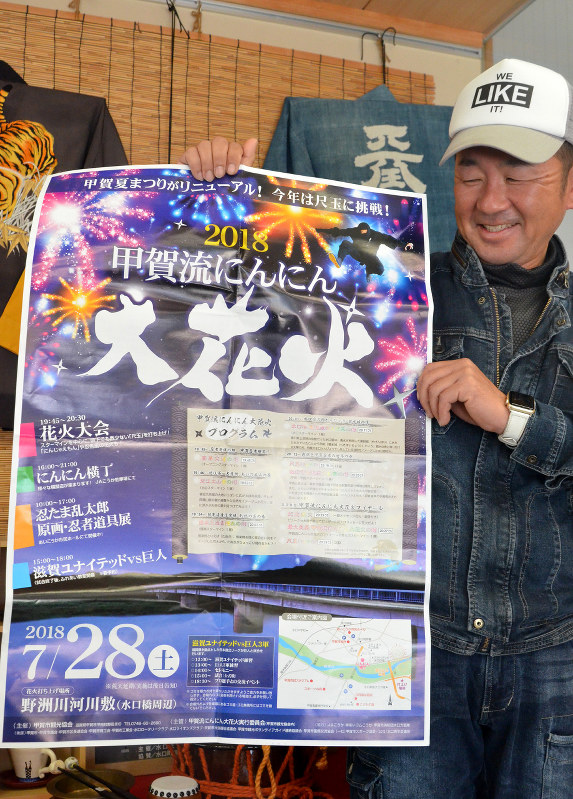 7月に予定した当時のポスターを手に「頼むから雨は降らないで」と願う斉内さん=滋賀県甲賀市の甲賀市ひと・まち街道交流館で2018年11月20日、礒野健一撮影