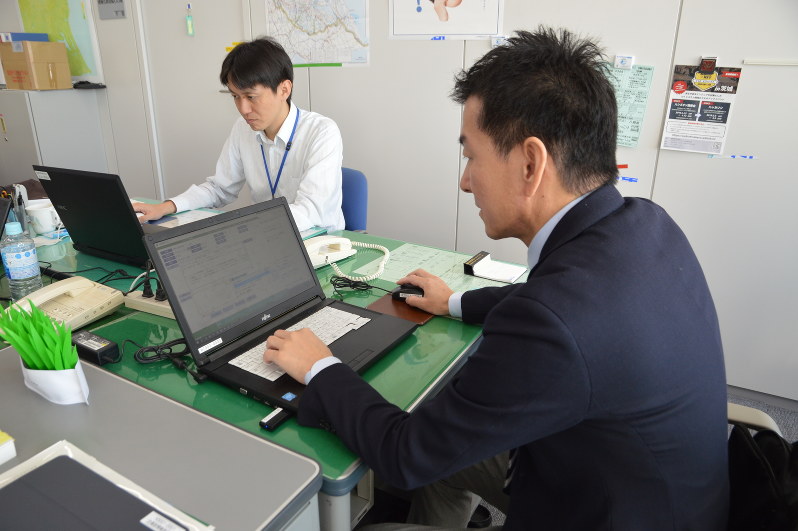 電子決裁システムで部下の起案文の決裁をする茨城県ICT戦略チームの戸沢雅彦さん(右)=水戸市の茨城県庁で11月21日、吉田卓矢撮影