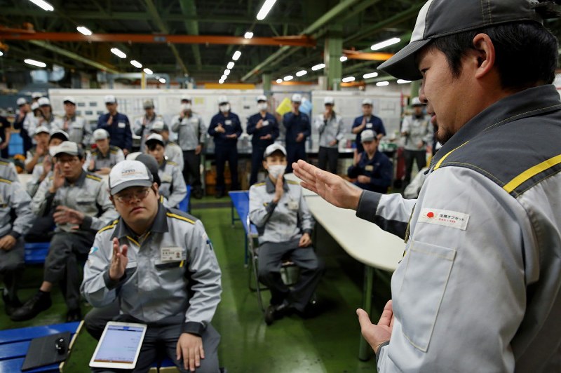 「忙しいけど安全作業でお願いします」。職場の朝礼で同僚に手話を教える聴覚障害者の深沢遼さん(手前右)=山梨県昭和町で2018年11月7日、小川昌宏撮影
