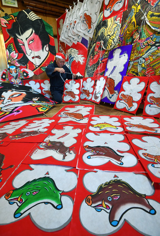 来年のえと「亥」にちなんだイノシシが描かれた和紙が並ぶ工房で、江戸凧制作を行う土岐幹男さん=千葉県長生村の凧工房ときで、手塚耕一郎撮影