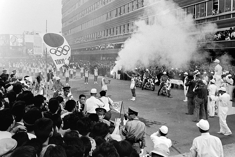前回の東京五輪で、大勢の市民が待つ大阪市天王寺区の中継地点に到着した聖火=1964年9月26日